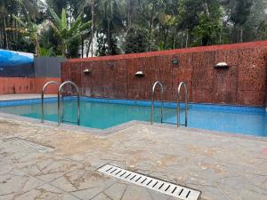 a swimming pool with two metal bars around it at Wayanad Shas Villa in Padinjarathara
