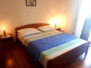 a bed in a bedroom with two lamps on tables at Wohnung Katarina Auf Der Insel Pag in Zubovići