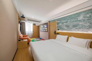 a hotel room with a large bed and a chair at Yuntuji Homestay, Yongding Tulou Branch, Longyan in Bajia