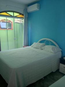 a bedroom with a white bed and a window at pousada top mix apt 202 in Florianópolis