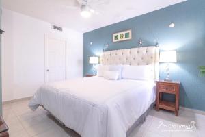 una camera da letto con un grande letto bianco con una parete blu di Sonoran Spa N502 a Campo del Medio Altre 9 foto