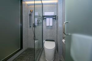 a bathroom with a toilet and a glass shower at Yuntuji Homestay, Yongding Tulou Branch, Longyan in Bajia +40 photos
