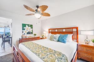 a bedroom with a bed and a ceiling fan at Kulakane 211 · KK 211 Updated OceanFront Whale Watching in Kahana +56 photos
