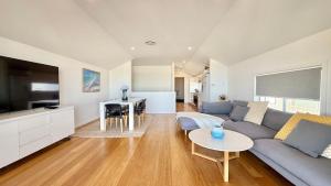 ケイブス・ビーチにあるOceanside Oasis at Caves Beach Villasのソファとテーブルのあるリビングルーム