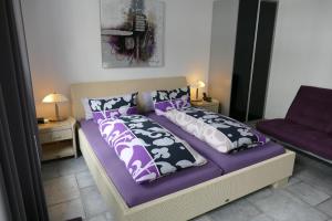a bedroom with a bed with purple sheets and pillows at Hotel La Principessa in Hameln
