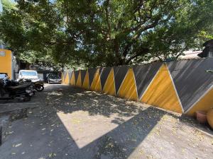 蓬蒂切里Ravi Krishna Inn的停车场里，树旁边有一道围栏。