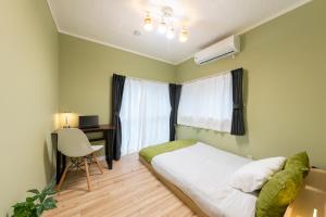 ein Schlafzimmer mit Bett, Schreibtisch und Fenster in der Unterkunft いっぷく in Yokosuka