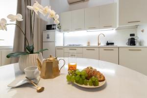a white kitchen with a plate of fruit on a table at TEATRUM LOFT Teatro Galli -Jacuzzi in camera in Rimini