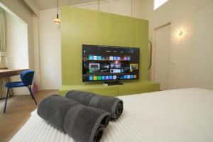a bedroom with a bed and a flat screen tv at day one space - BTS On Nut - Live Above Cowork Cafe in Bangkok