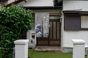 eine Haustür mit einem Gemälde darauf in der Unterkunft いっぷく in Yokosuka