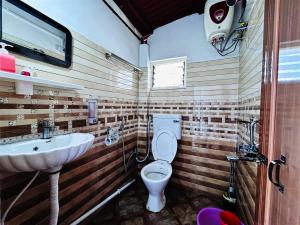 a bathroom with a toilet and a sink at Greenview108 in Kurseong