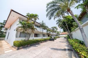 a street in front of a building with palm trees at View Talay Longstay in Jomtien Beach