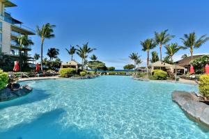 a swimming pool at a resort with palm trees at Honua Kai 322 · HK 322 Luxurious Kaanapali BeachFront 2BD Pool A in Lahaina