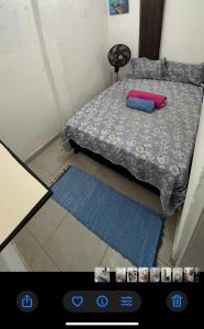 a view of a bedroom with a bed and a blue rug at Kitnet Dream House 1 in Bayeux +12 photos