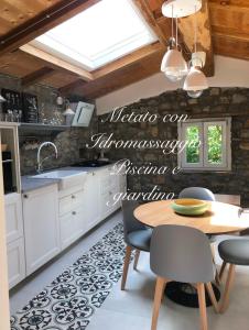 CasabascianaにあるMetato con piscina e giardinoの白いキャビネットとテーブルと椅子のあるキッチン