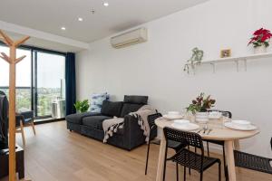 ein Wohnzimmer mit Sofa und Tisch in der Unterkunft 2Bbr Apt SouthYarra Steps from Chapel St TF92125 in Melbourne