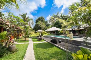 ogród z basenem i ośrodek w obiekcie Puri Kurnia Ayu w mieście Ubud