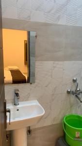 a bathroom with a sink and a mirror and a bed at Shreeramyadham vrindavan in Vrindāvan