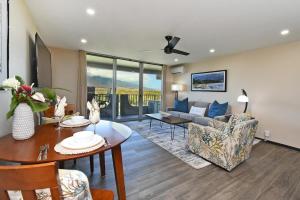a living room with a couch and a table at Nani Kai Hale 605 · NKH 605 Remodeled BeachFront w Pool AC Sandy in Kihei