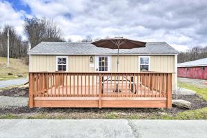 a house with an umbrella on a wooden deck at Clydesdale Cottage & Brandenburger Suite at Equestrian House PA in Pleasant Mount
