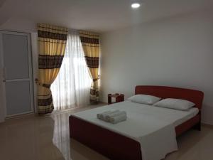 a bedroom with a bed with two towels on it at Travelhubs Rooms in Kandy