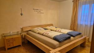 a bed with pillows on it in a room at Ferienhof Krug in Wiggensbach