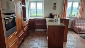 a kitchen with wooden cabinets and a counter top at Ferienhof Krug in Wiggensbach +3 photos