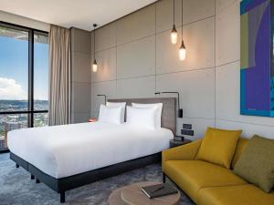 una habitación de hotel con una cama y un sofá en Pullman Tbilisi Axis Towers, en Tiflis