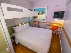 フォルタレザにあるIbis Budget Fortaleza Praia de Iracemaのベッドとテレビのある小さな部屋