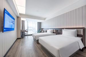 Ένα ή περισσότερα κρεβάτια σε δωμάτιο στο Hanting Hotel Shanghai Taopu New Village Subway Station