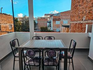 a table and chairs on a balcony with a view at Departamento en Centro Histórico in Cuenca