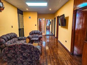 un pasillo con sofás y sillas en una habitación en Departamento en Centro Histórico, en Cuenca