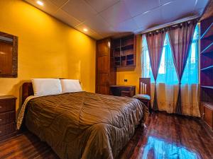 1 dormitorio con 1 cama en una habitación amarilla en Departamento en Centro Histórico, en Cuenca