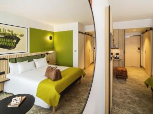 a hotel room with a large bed and a mirror at Mercure Katowice Centrum in Katowice