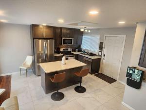 a kitchen with an island in the middle of it at Modern Family Home with guest heat garage, Pet-Friendly!- NO BASEMENT in Edmonton