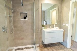 a bathroom with a shower with a sink and a mirror at Amber Mist Villa - Two in Bright +19 photos