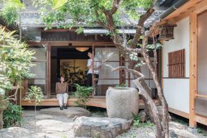 a person sitting on the porch of a house at 宿 -Shuku- in Inuyama