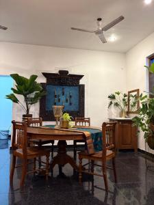 a dining room with a wooden table and chairs at Yali Homestay in Kuilapayam