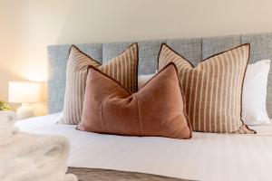 a bed with brown pillows on top of it at Amber Mist Villa - Two in Bright