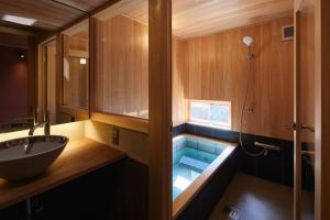 a bathroom with a tub with a shower and a sink at 宿 -Shuku- in Inuyama