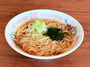 a bowl of noodles on a wooden table at Fukui Manten Hotel Ekimae in Fukui