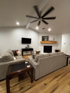 a living room with two couches and a ceiling fan at Tucker Creek Oasis in Conway