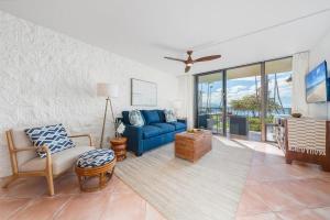 een woonkamer met een blauwe bank en een tv bij Kanai A Nalu 211 · KAN 211 Remodeled OceanFront 2BD for Whale Wa in Wailuku