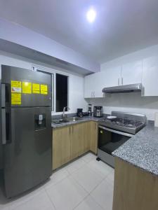 a kitchen with stainless steel appliances and a counter at Cozy 3br apartment near to airport & beaches in La Cana