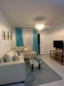 a living room with a couch and a television at Cozy 3br apartment near to airport & beaches in La Cana