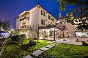 a large white building with a yard in front of it at Zhangjiajie Tianchong Yunhai Resort Hotel in Zhangjiajie
