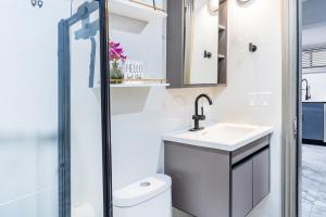 Un baño con inodoro, lavabo y ducha. en The Hideaway Suite, en Bellerose Terrace