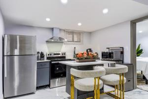 cocina con nevera de acero inoxidable y 2 taburetes en The Hideaway Suite, en Bellerose Terrace 5 fotos más