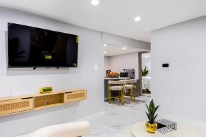 Una sala de estar con un televisor de pantalla plana en una pared. en The Hideaway Suite, en Bellerose Terrace