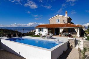 a villa with a swimming pool in front of a house at Holiday home in Vrbnik - Insel Krk 13634 in Vrbnik